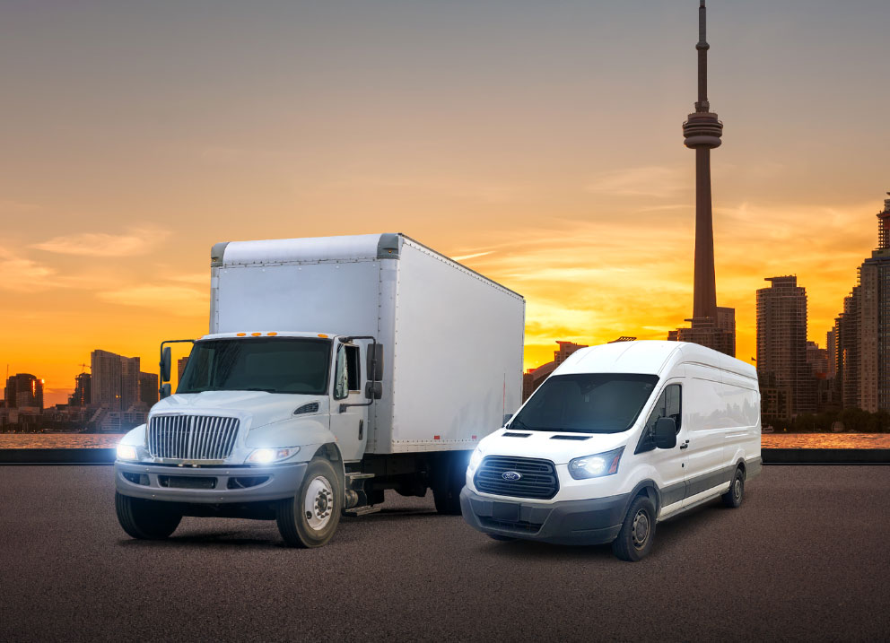 White city truck and courier van carrying expedited shipments parked in front of Toronto, ON cityscape